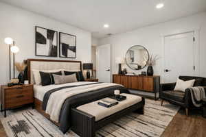 Spacious bedroom featuring wood-finish flooring, recessed lighting, and white trim