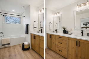 Bathroom featuring a wood-finish double vanity with white countertops, undermount sinks, and matte black fixtures