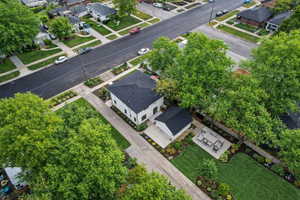 Contemporary residence with a detached accessory building, concrete driveway, and a manicured lawn