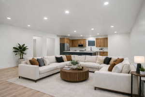 Open-concept living area with wood-finish flooring, recessed lighting, and white wall finishes