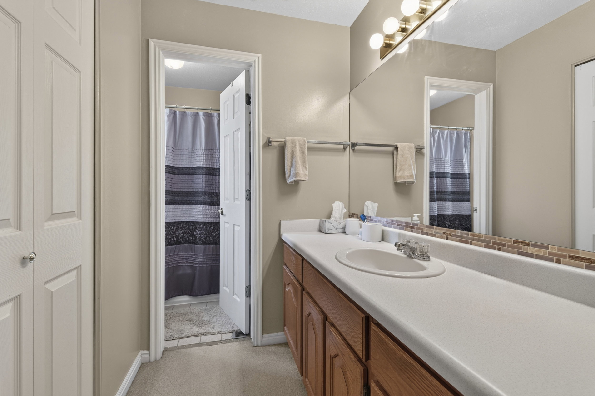 Bathroom vanity featuring an integrated sink, laminate countertop, and wood-finish cabinetry