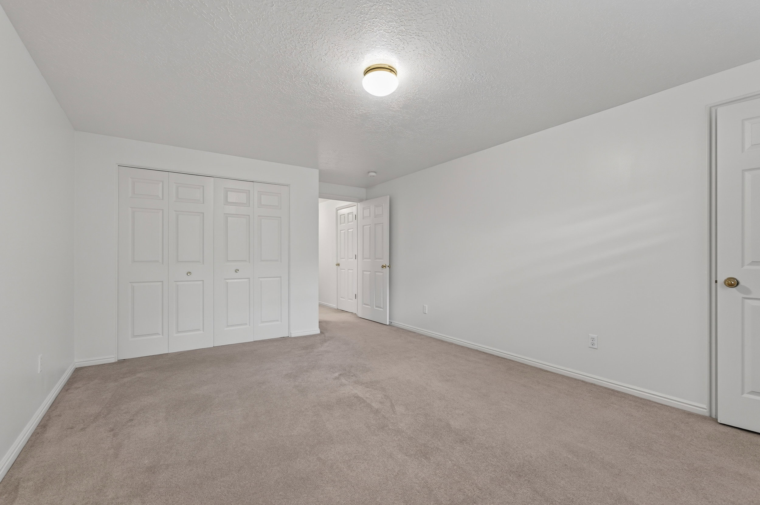 Spacious room featuring neutral carpeting and white walls