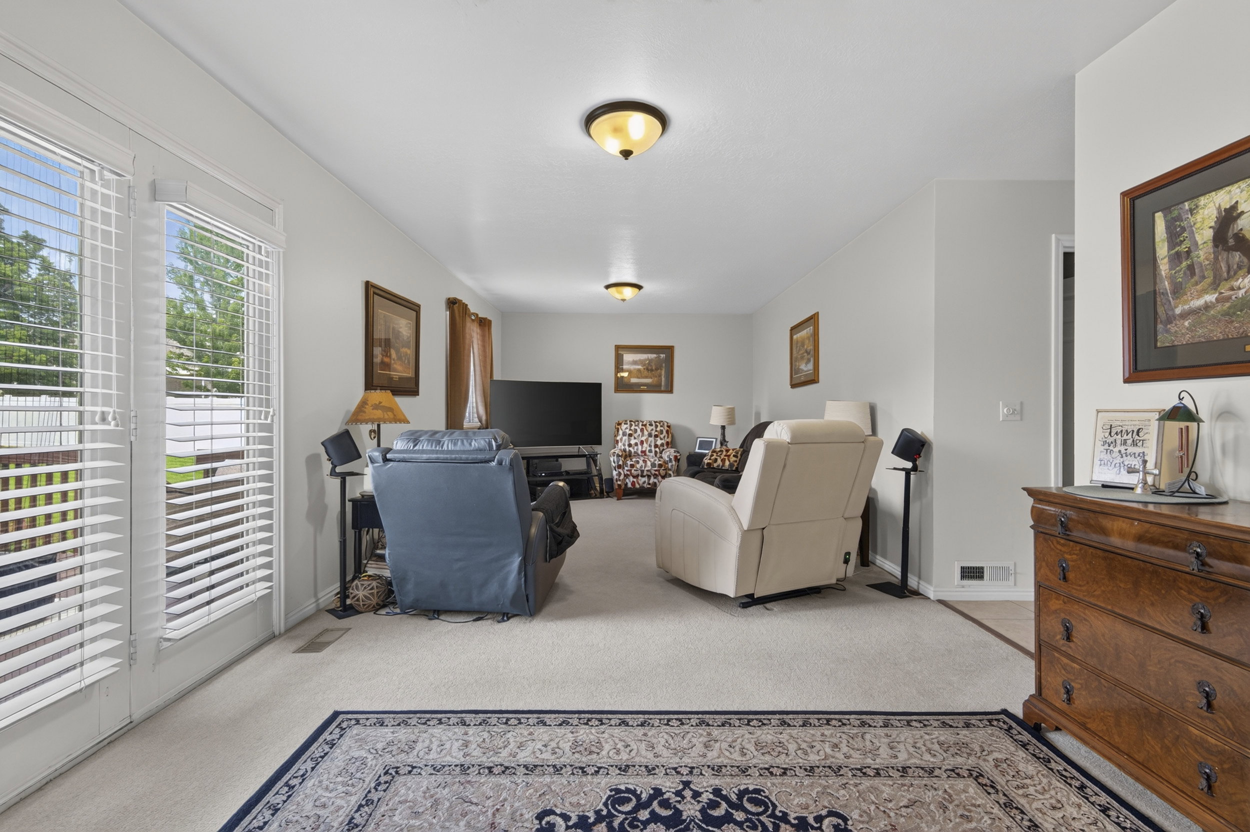 Spacious interior room with light-colored walls and wall-to-wall carpeting