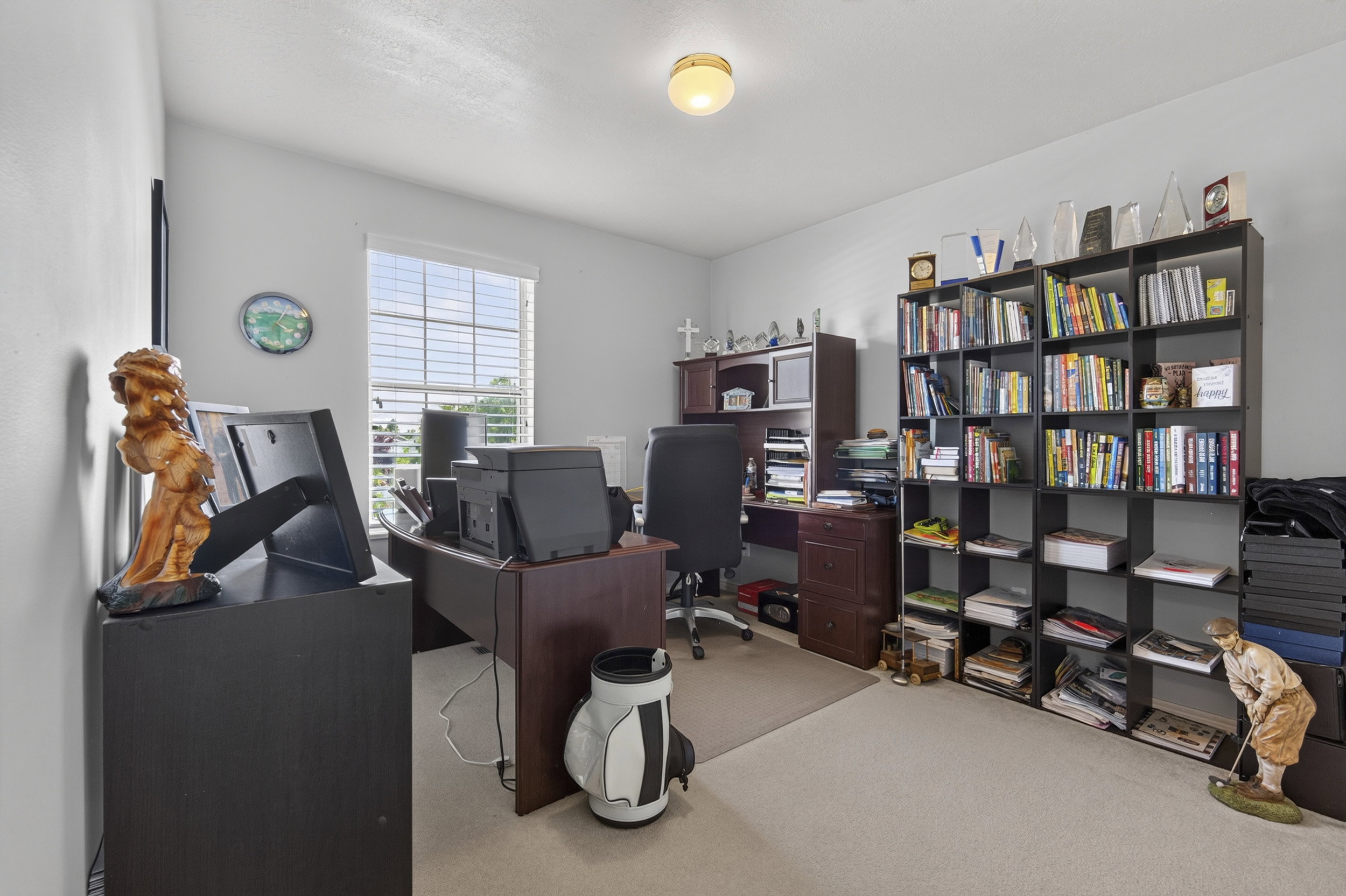 Carpeted room with a ceiling-mounted light fixture, featuring a window with horizontal blinds