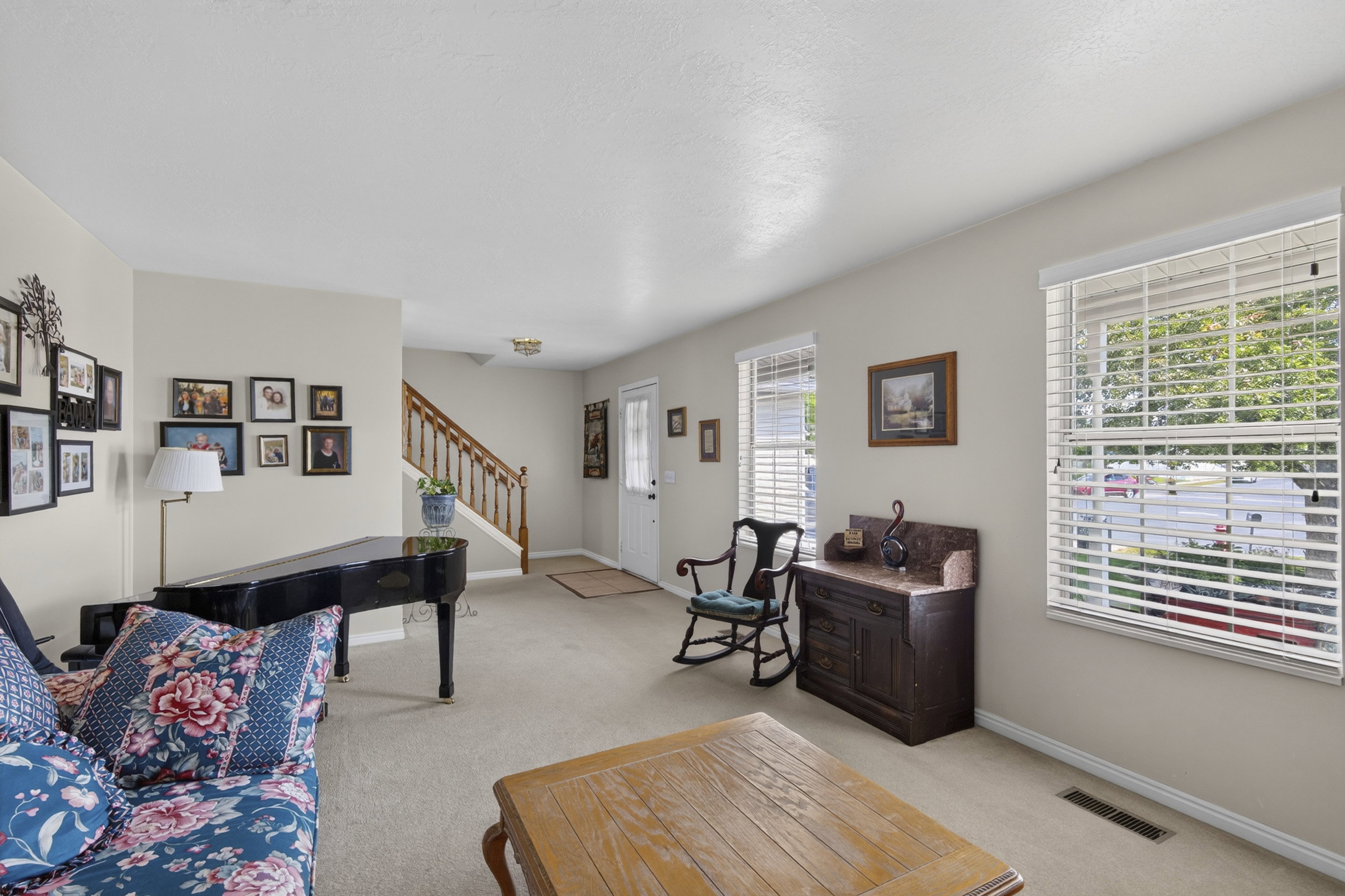 Open living area featuring neutral carpet flooring and light-toned walls