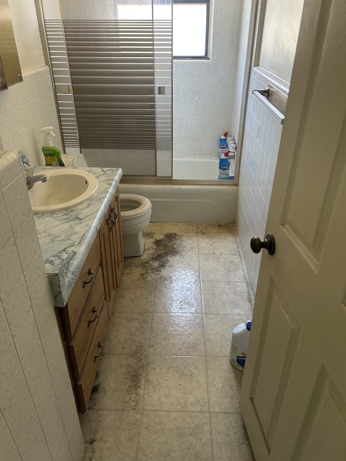 Bathroom featuring a single vanity with a patterned countertop, wood-finish cabinetry, and a drop-in sink