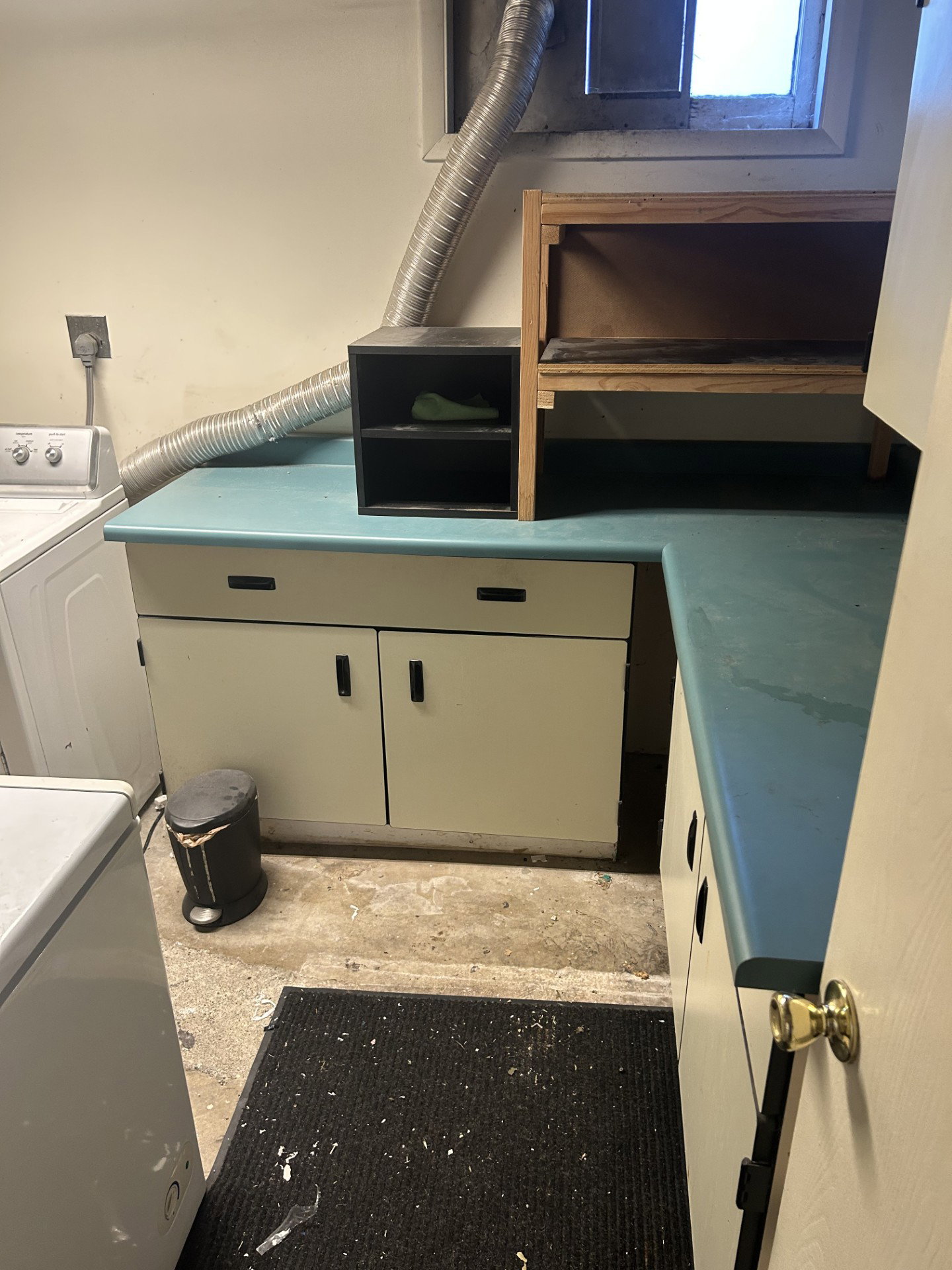 Utility area with built-in cabinetry, light blue countertops, and white appliances