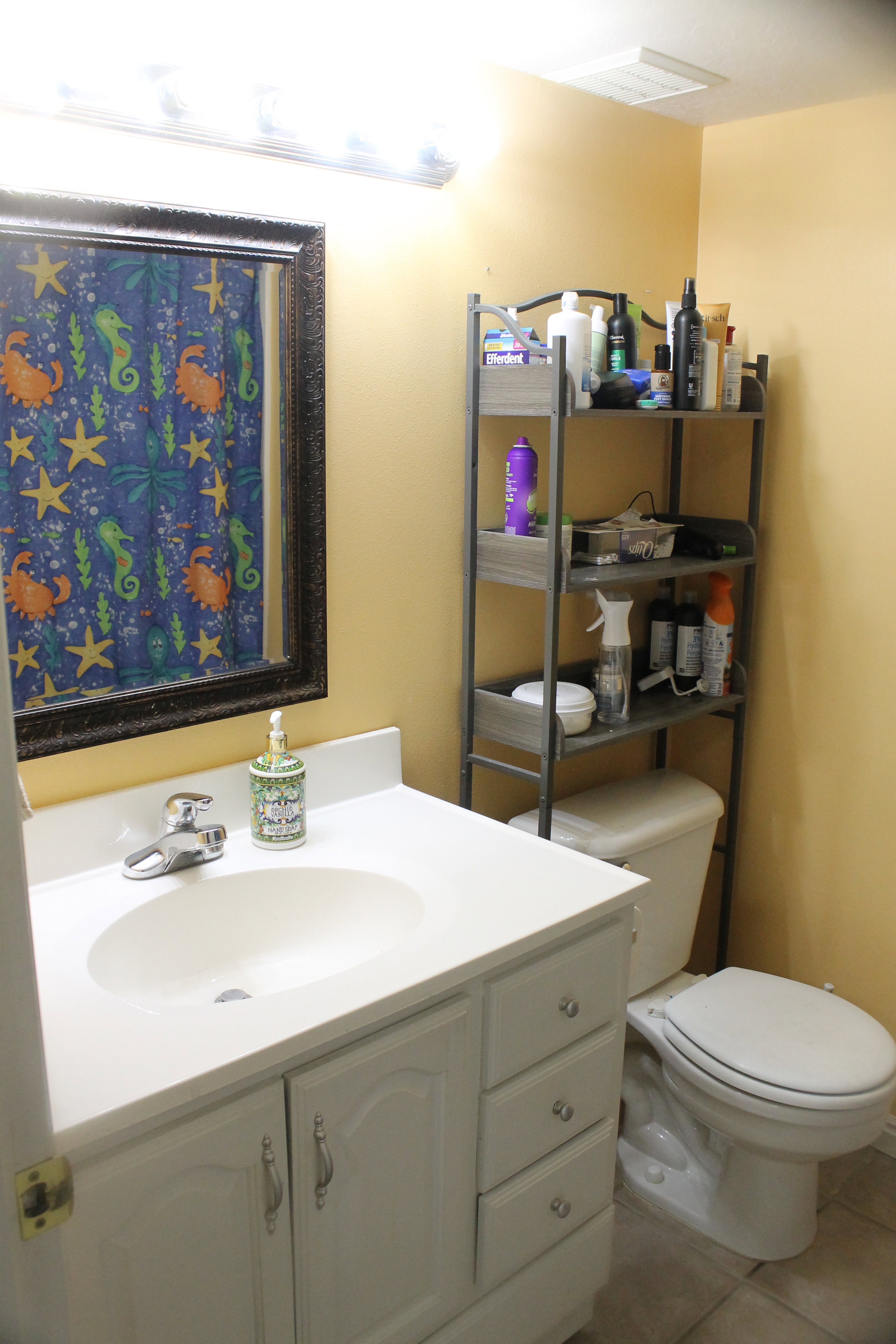 Bathroom featuring a white vanity with integrated sink, chrome faucet, and storage cabinetry