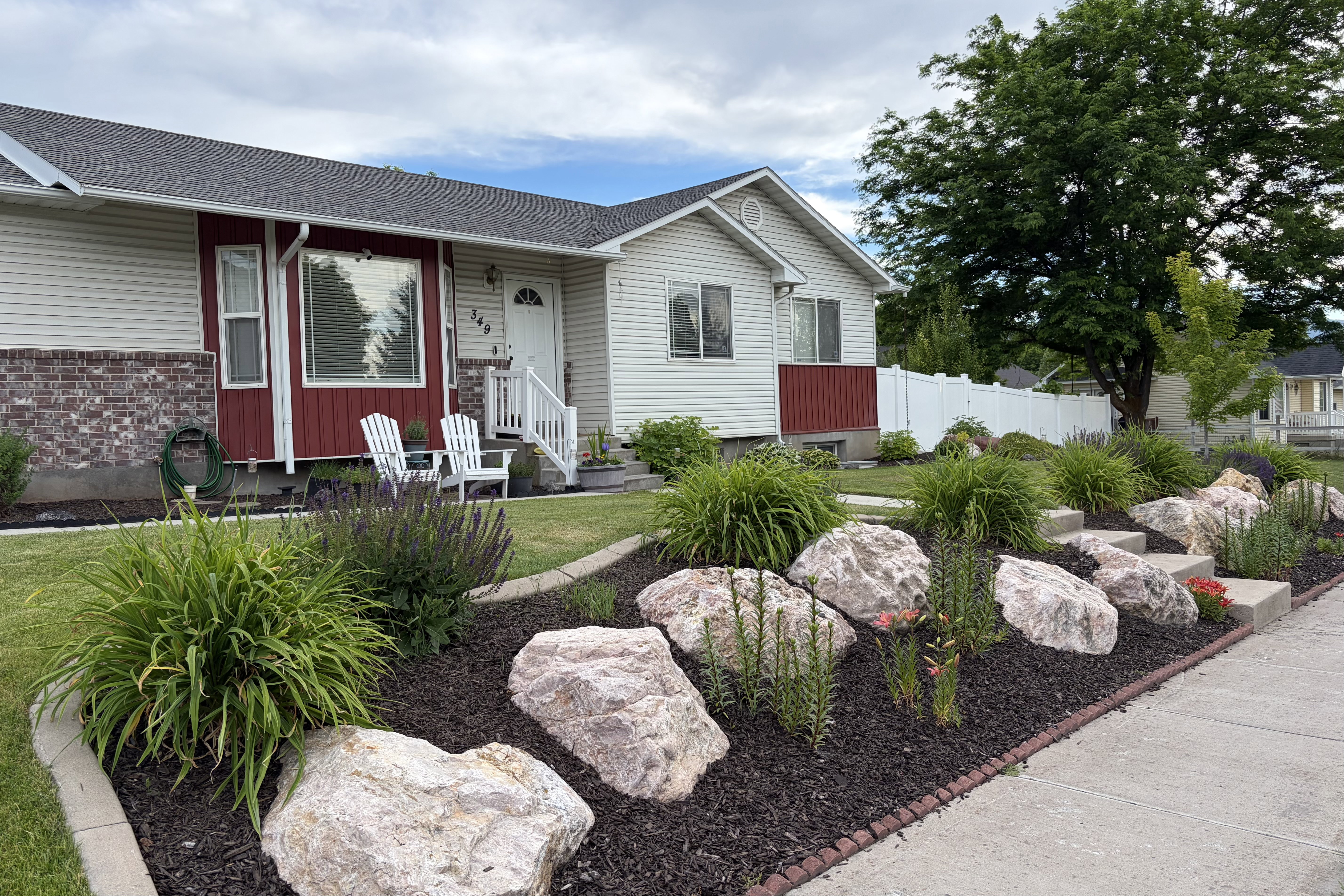 Exterior featuring light siding with a red accent panel and brick detailing