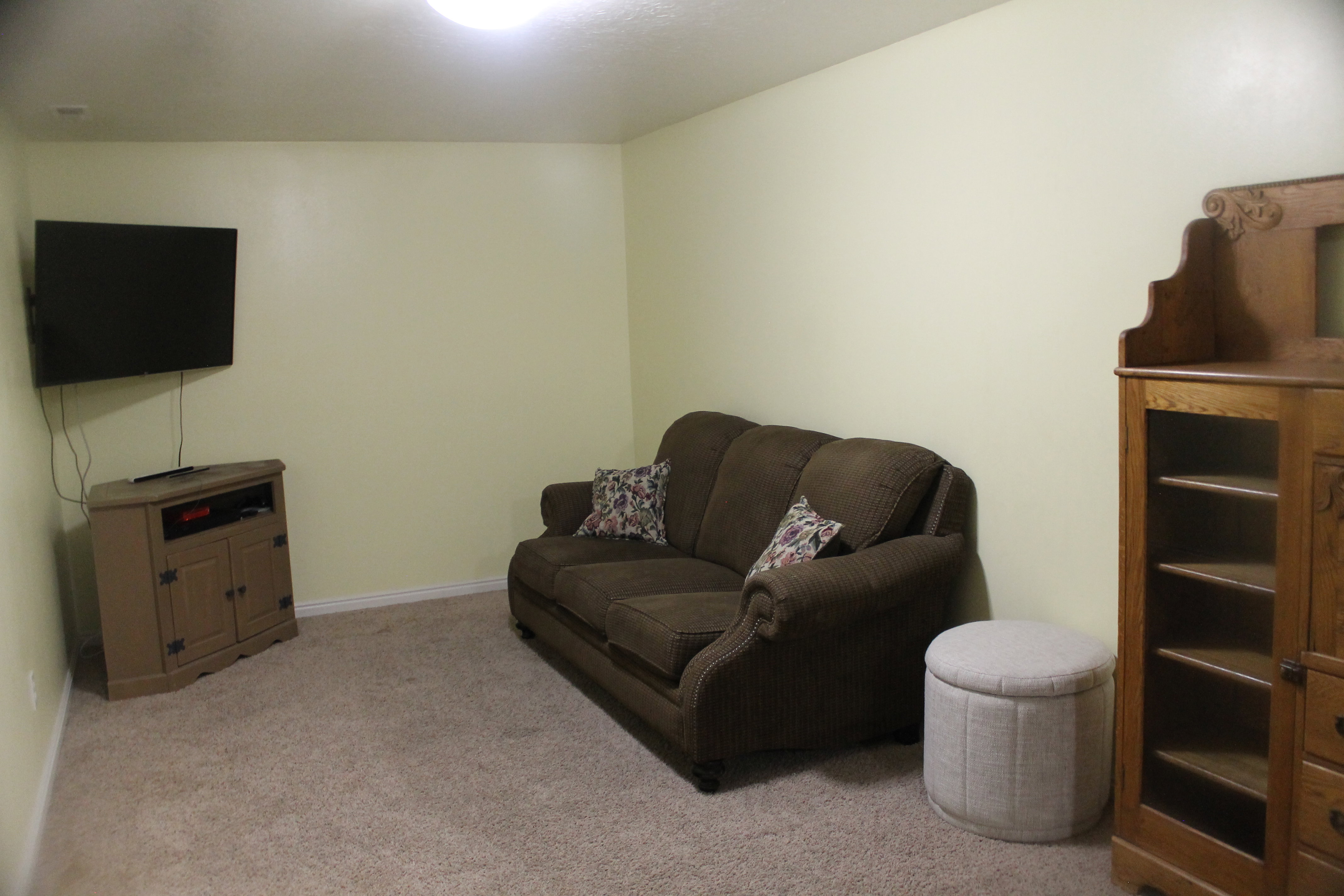 Carpeted room featuring a ceiling-mounted light fixture and light-toned wall paint