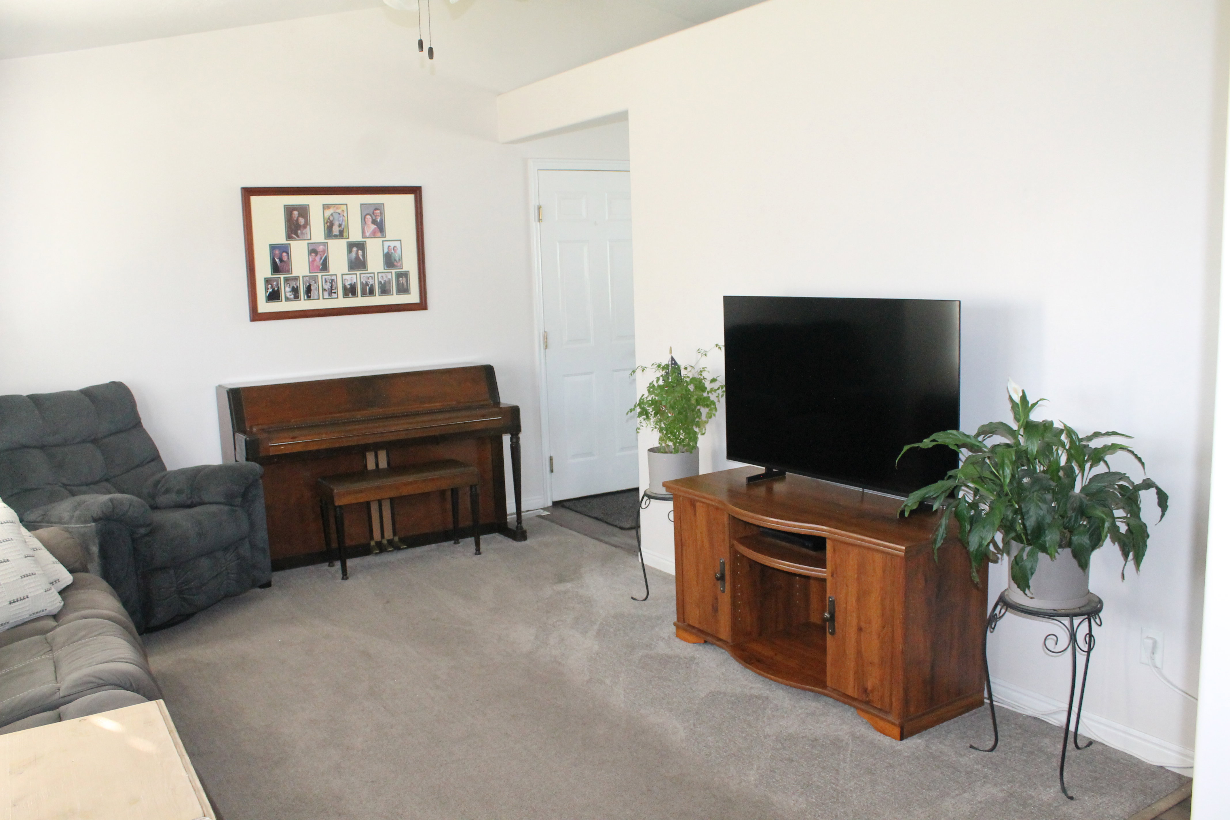Spacious living area featuring light-toned carpeting and vaulted ceilings