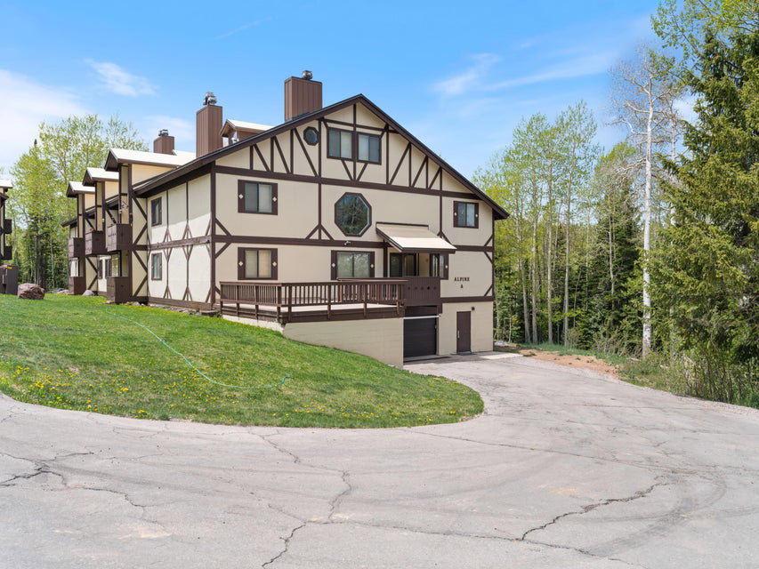 Tudor-style exterior with decorative half-timbering, multiple balconies, a covered entry, and an octagon window feature