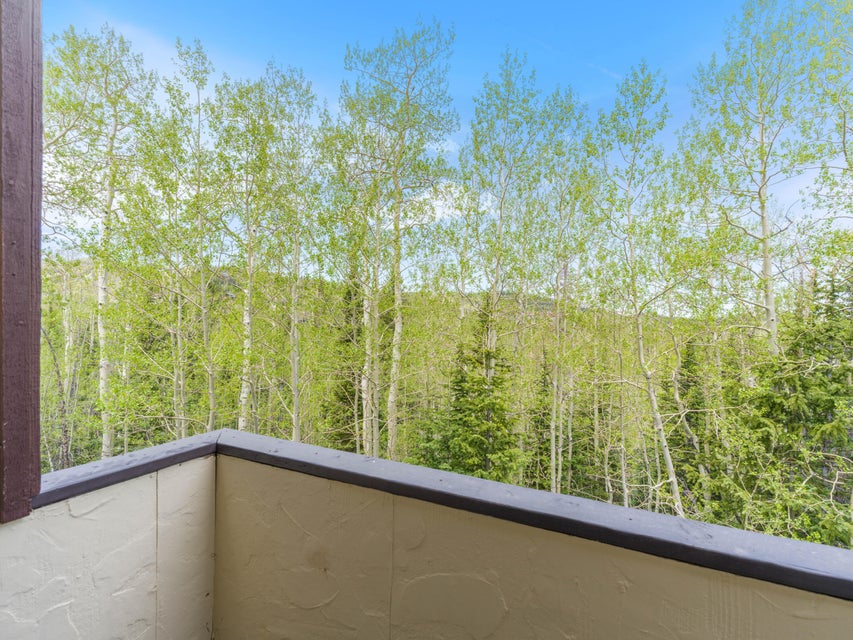 Outdoor balcony featuring textured stucco walls and a dark cap railing