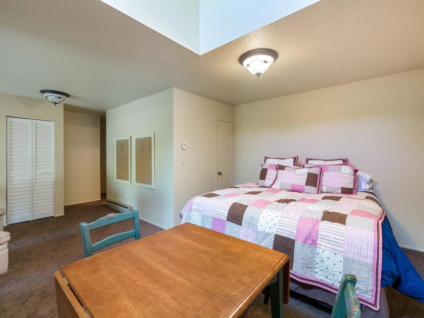 Carpeted room featuring a drop-leaf table and a closet with bifold doors