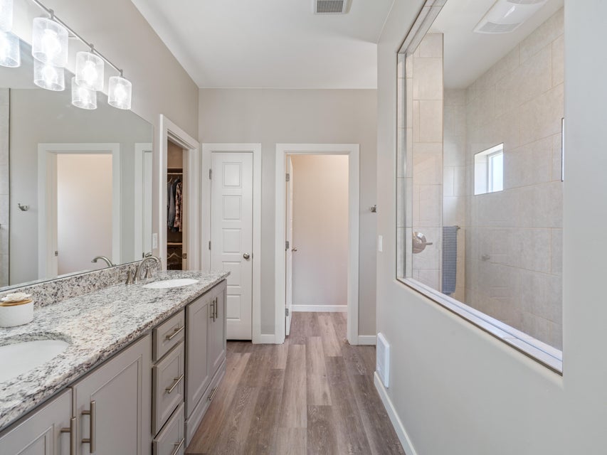 Double vanity featuring light grey cabinetry, dual undermount sinks, and a speckled countertop