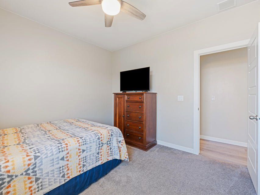 Neutral wall color with recessed lighting and a ceiling fan
