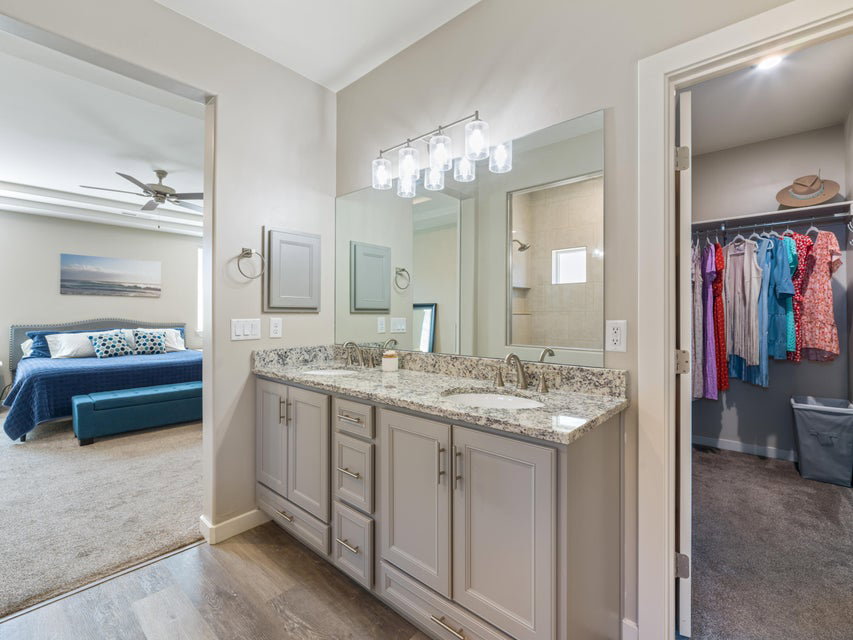 Double vanity featuring a granite countertop, undermount sinks, and chrome faucets