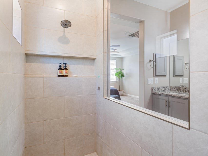 Tiled shower with a built-in niche and a chrome shower head