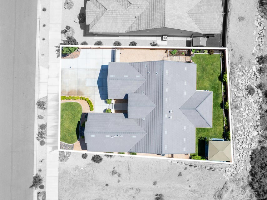 Overhead perspective highlighting the property's footprint, featuring a multi-gabled roofline, concrete driveway, and established landscaping