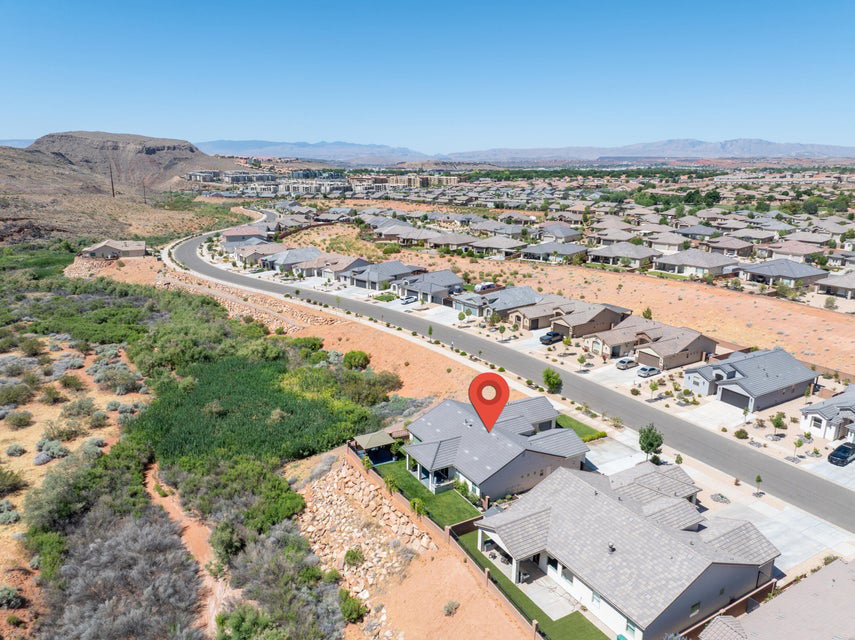 Expansive neighborhood featuring single-story homes with attached garages, paved streets, and arid landscaping