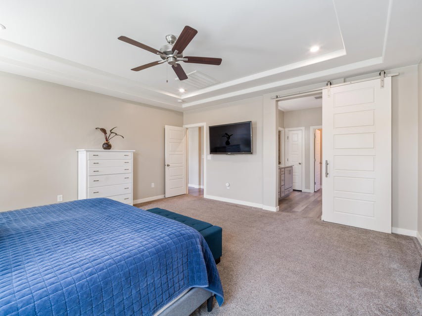 Spacious room featuring a tray ceiling, recessed lighting, and a ceiling fan