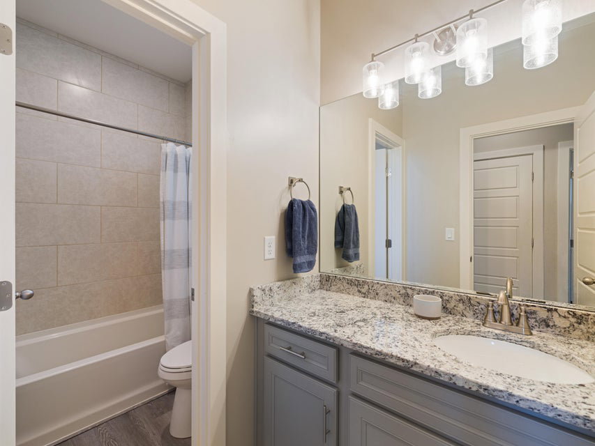 Bathroom vanity featuring a speckled countertop, a single basin sink, and gray cabinetry
