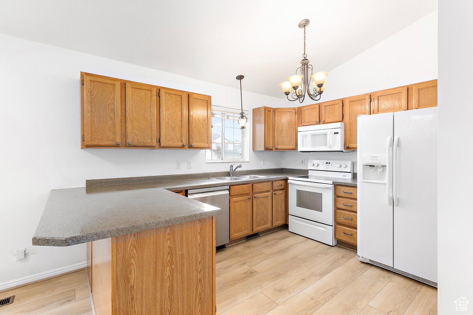 Kitchen featuring wood cabinetry, laminate countertops, and wood-finish flooring