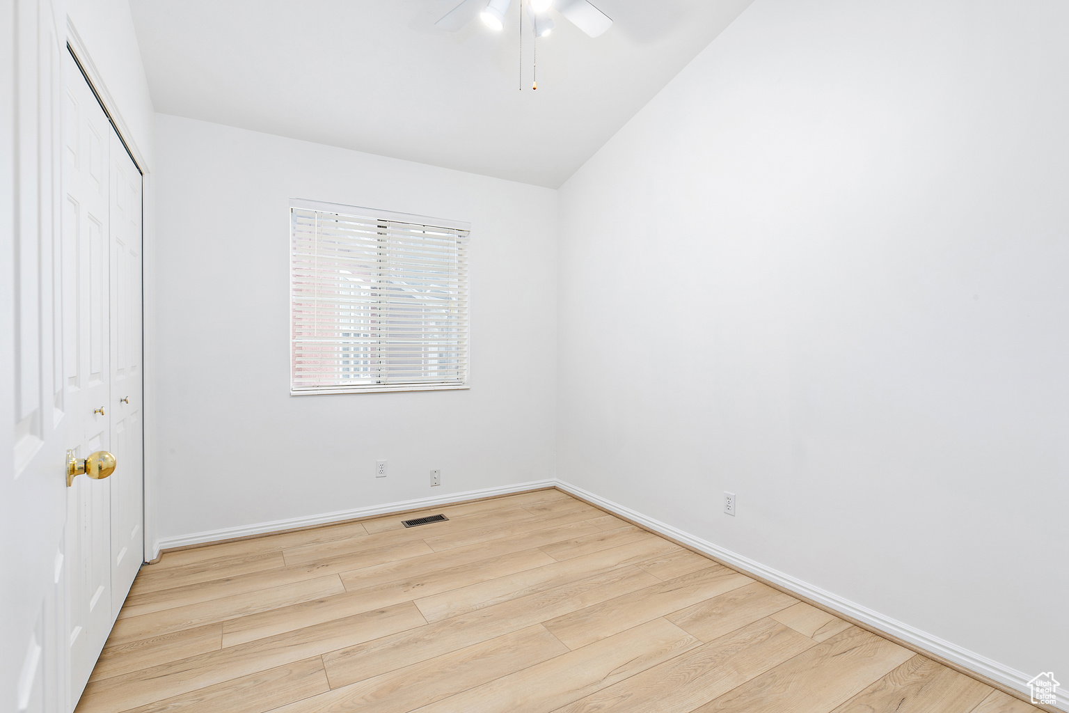 Room featuring wood-finish flooring, white baseboards, a white ceiling fan, and a window with horizontal blinds