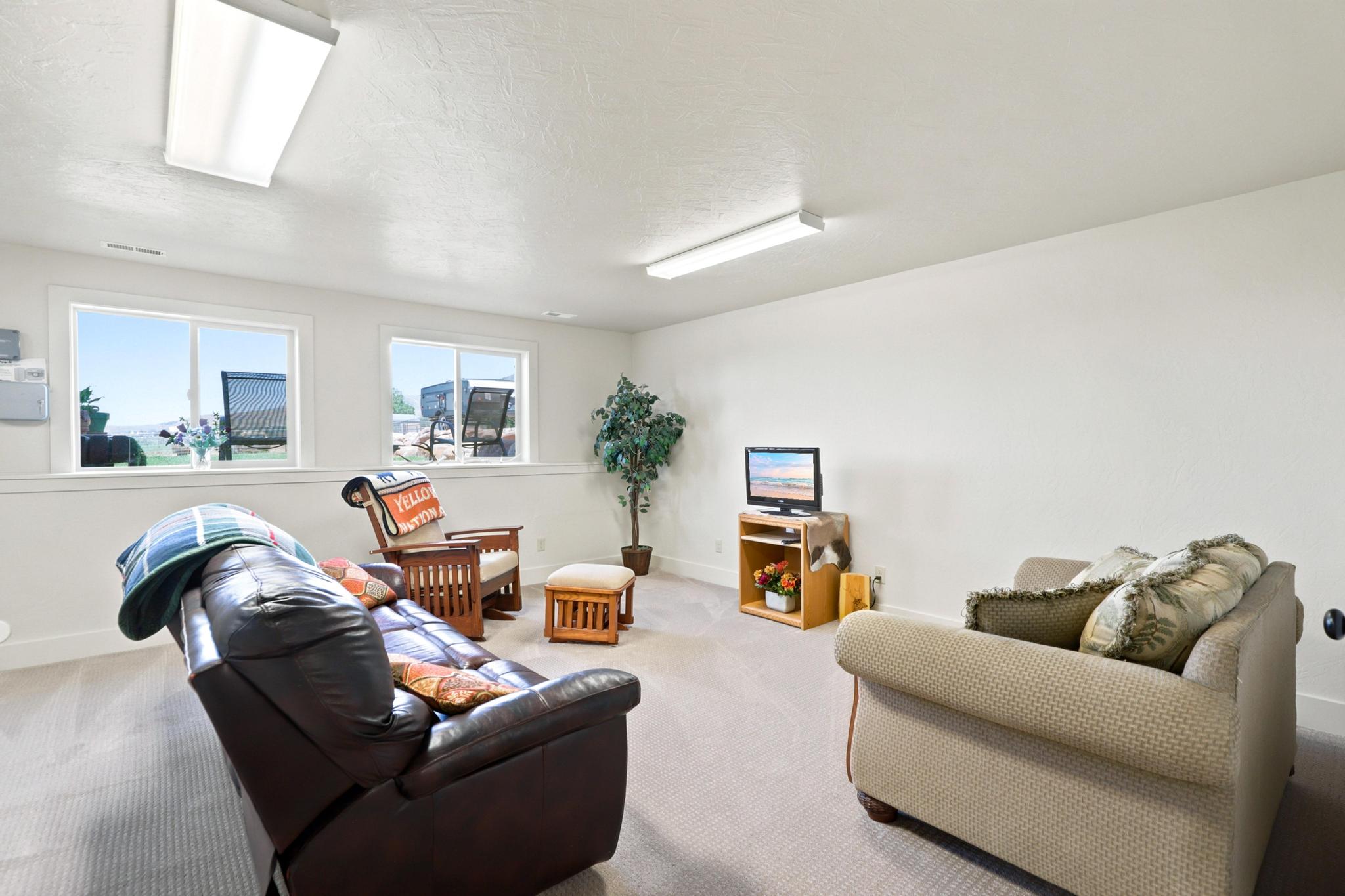 Spacious room featuring light carpeting and white walls