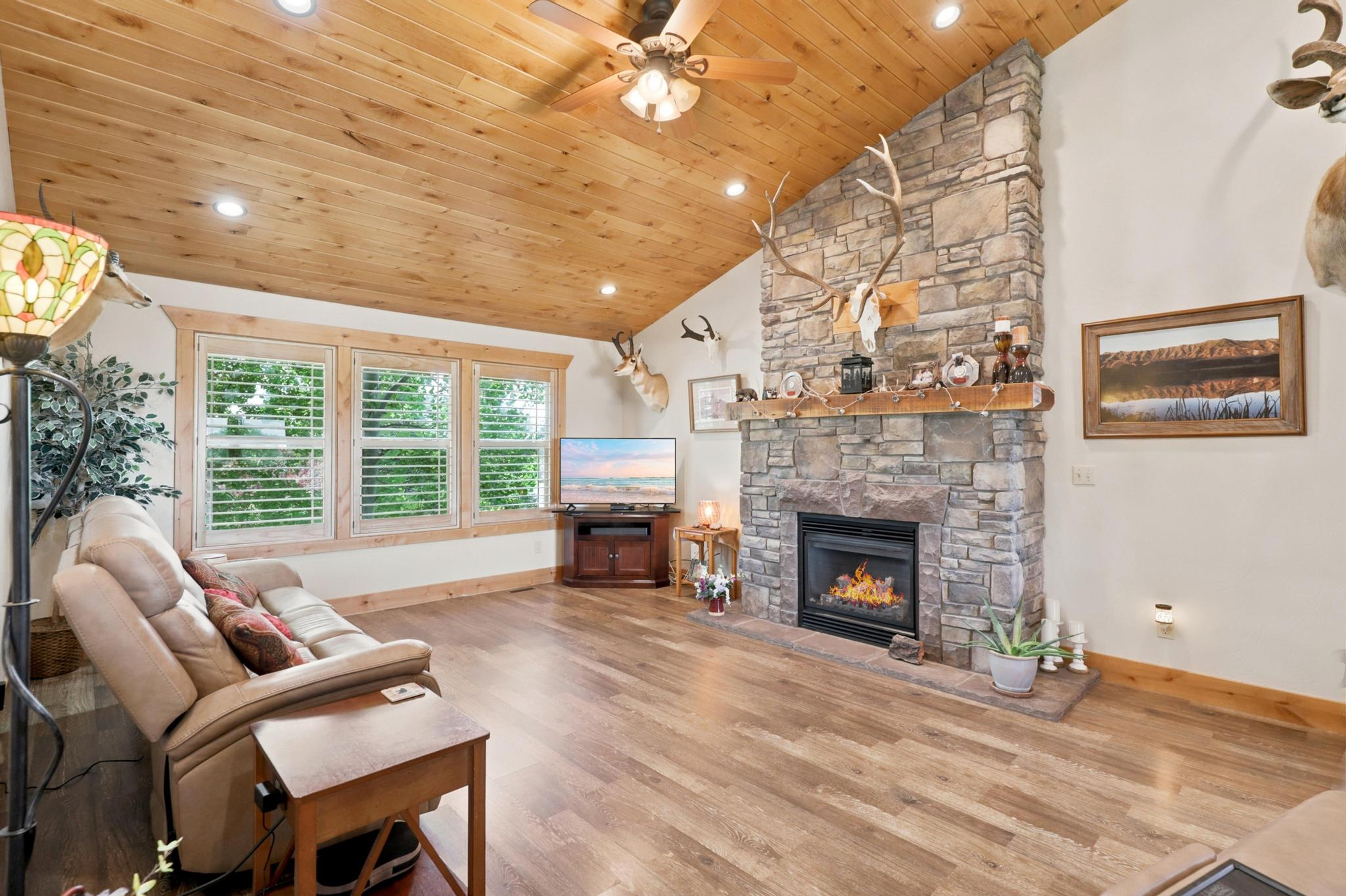 Vaulted wood-paneled ceiling with recessed lighting and a ceiling fan