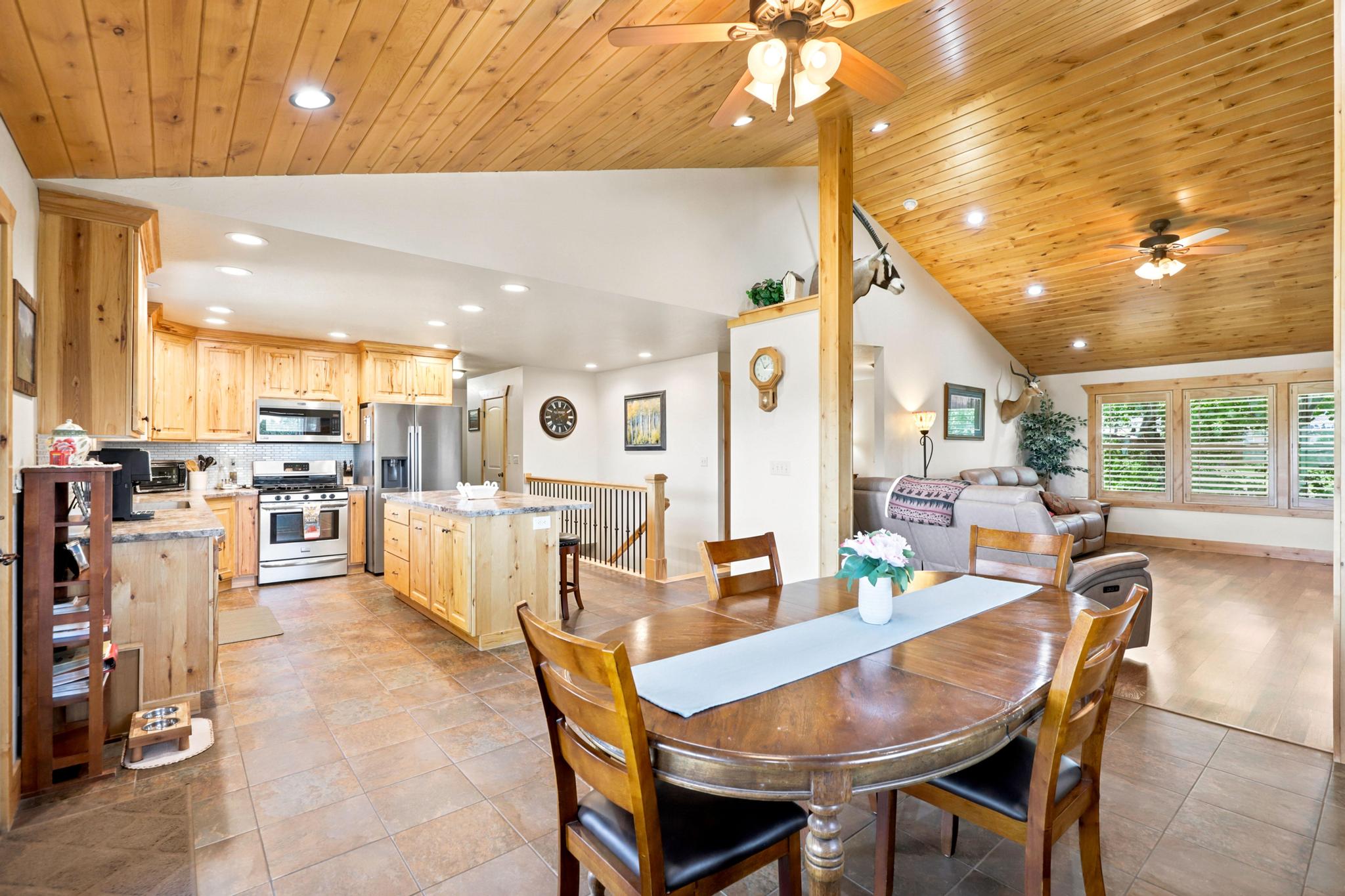 Open-concept living space featuring a wood-panel vaulted ceiling, recessed lighting, and ceiling fans