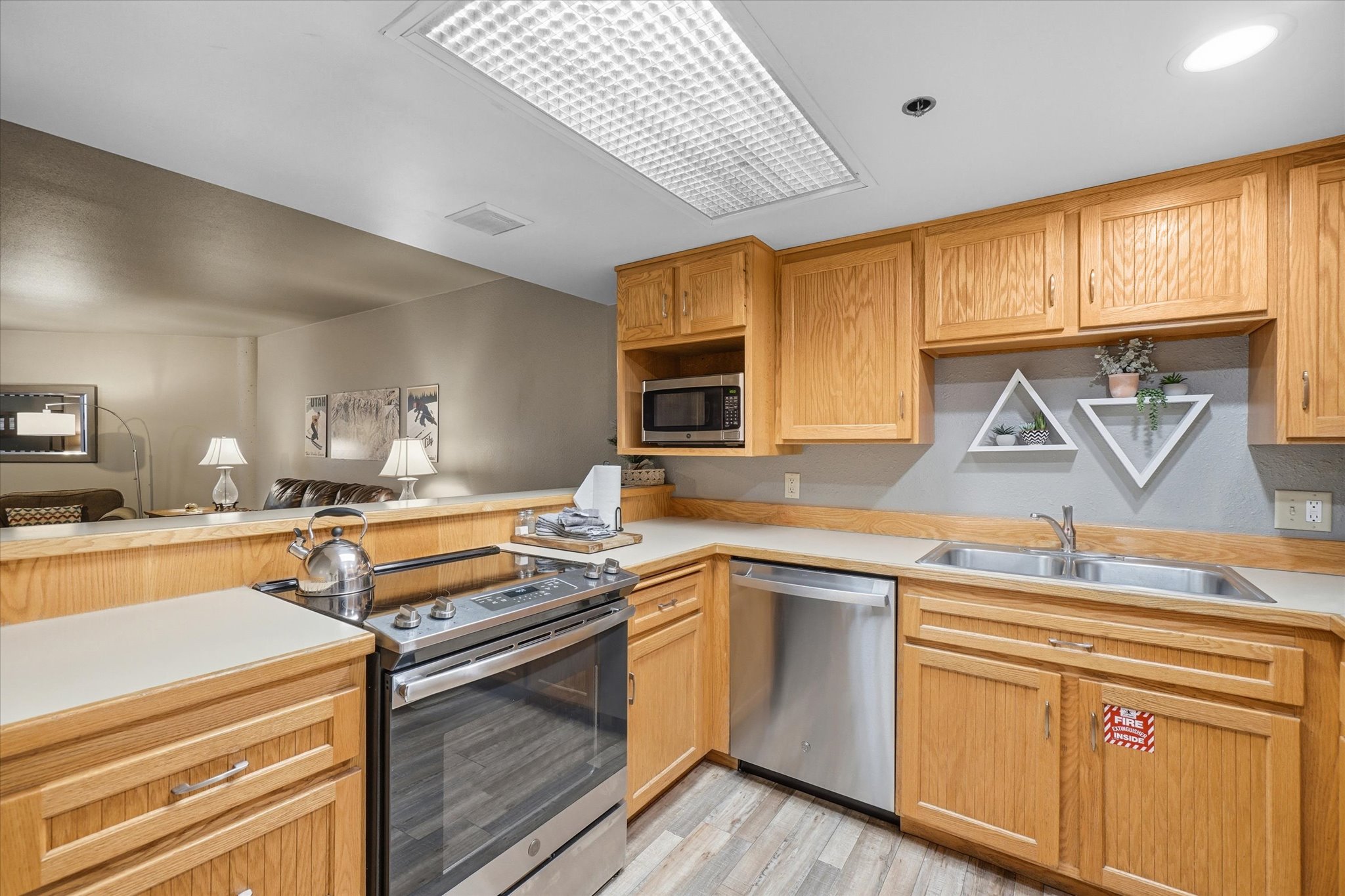 Kitchen featuring wood-finish cabinetry, stainless steel appliances, and a double basin sink