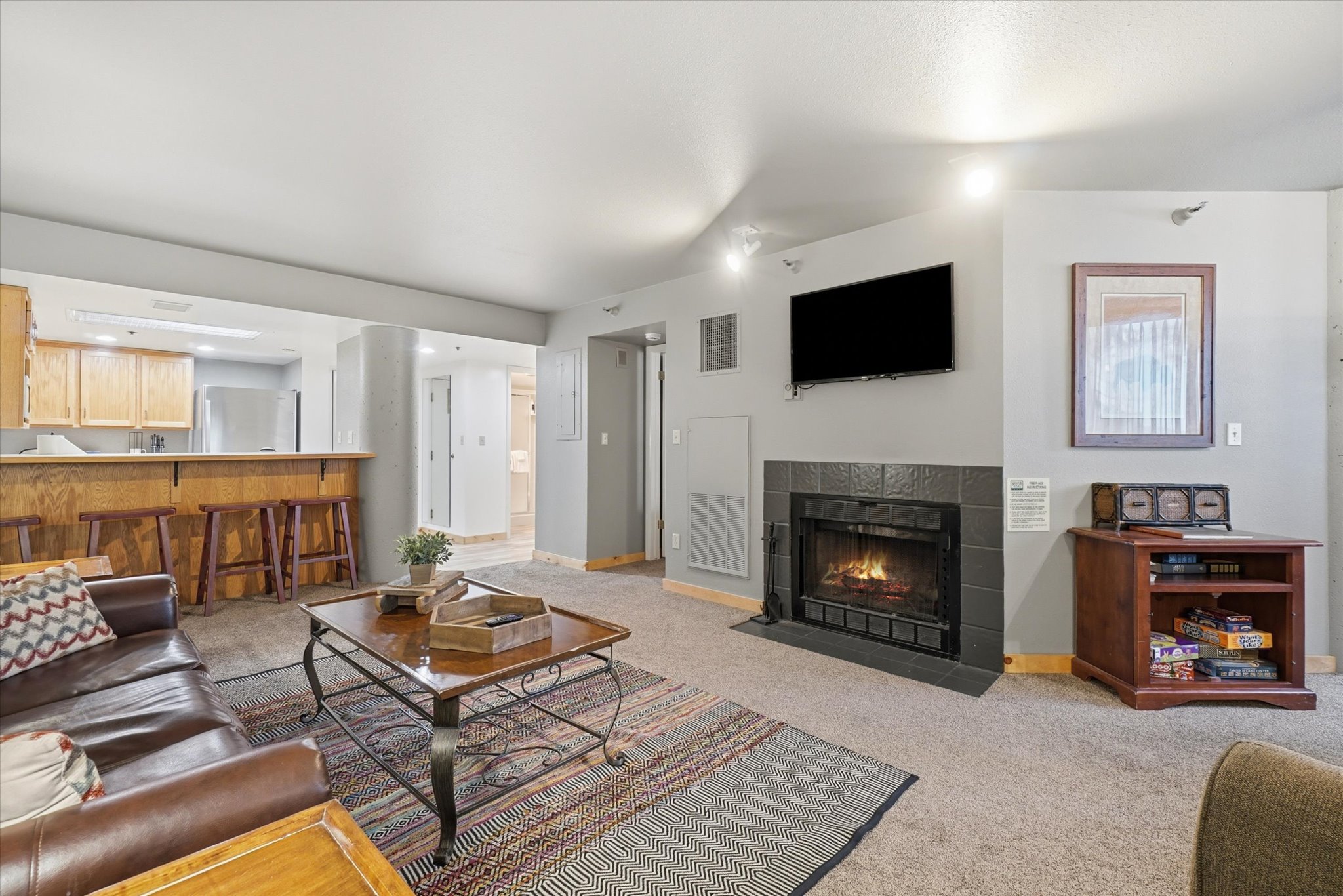 Living area featuring a floor-to-ceiling fireplace with dark tile surround and hearth