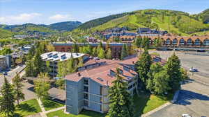 Multi-story residential structure featuring a light blue facade and a distinctive reddish-brown roof