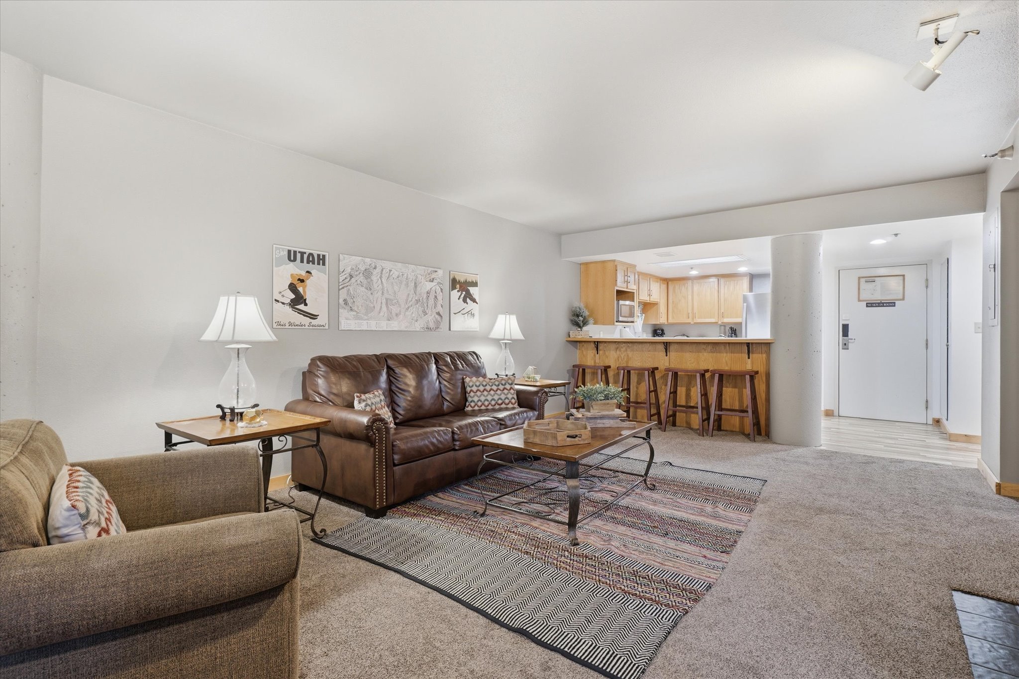Open-concept living space featuring a breakfast bar, wood-finish kitchen cabinetry, recessed lighting, and track lighting
