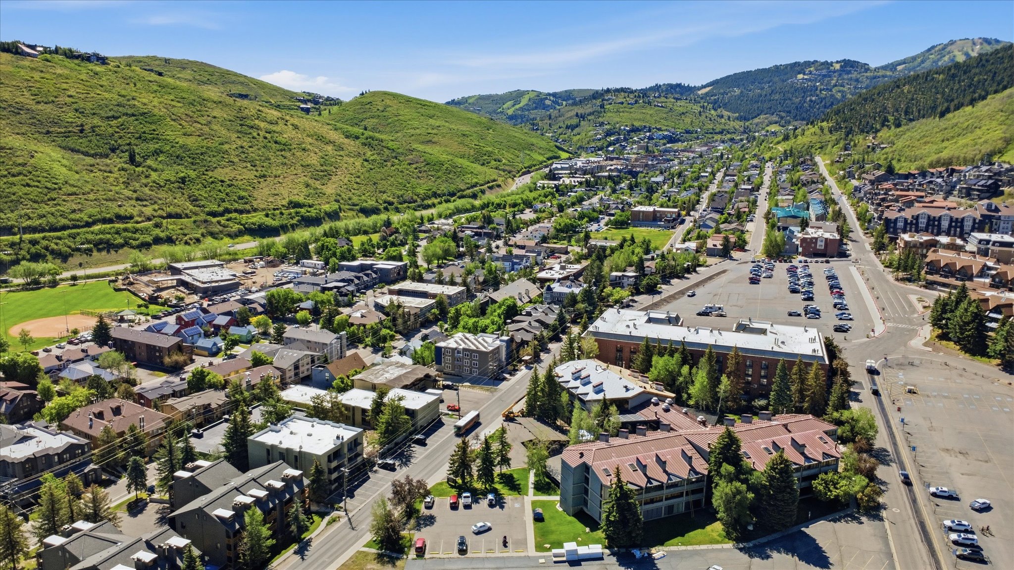 Expansive aerial perspective showcasing a mountainous terrain encompassing residential and commercial structures