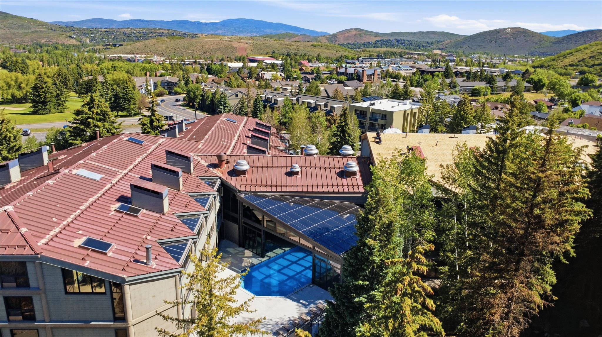 Architectural complex featuring a multi-level roofline, solar panel installation, and a prominent skylight structure