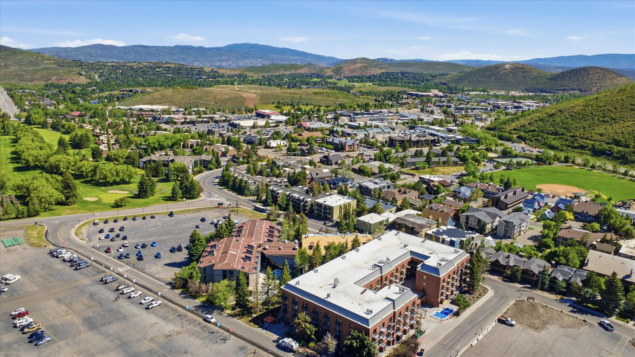 Aerial perspective showcasing a vibrant community surrounded by rolling hills and lush greenery