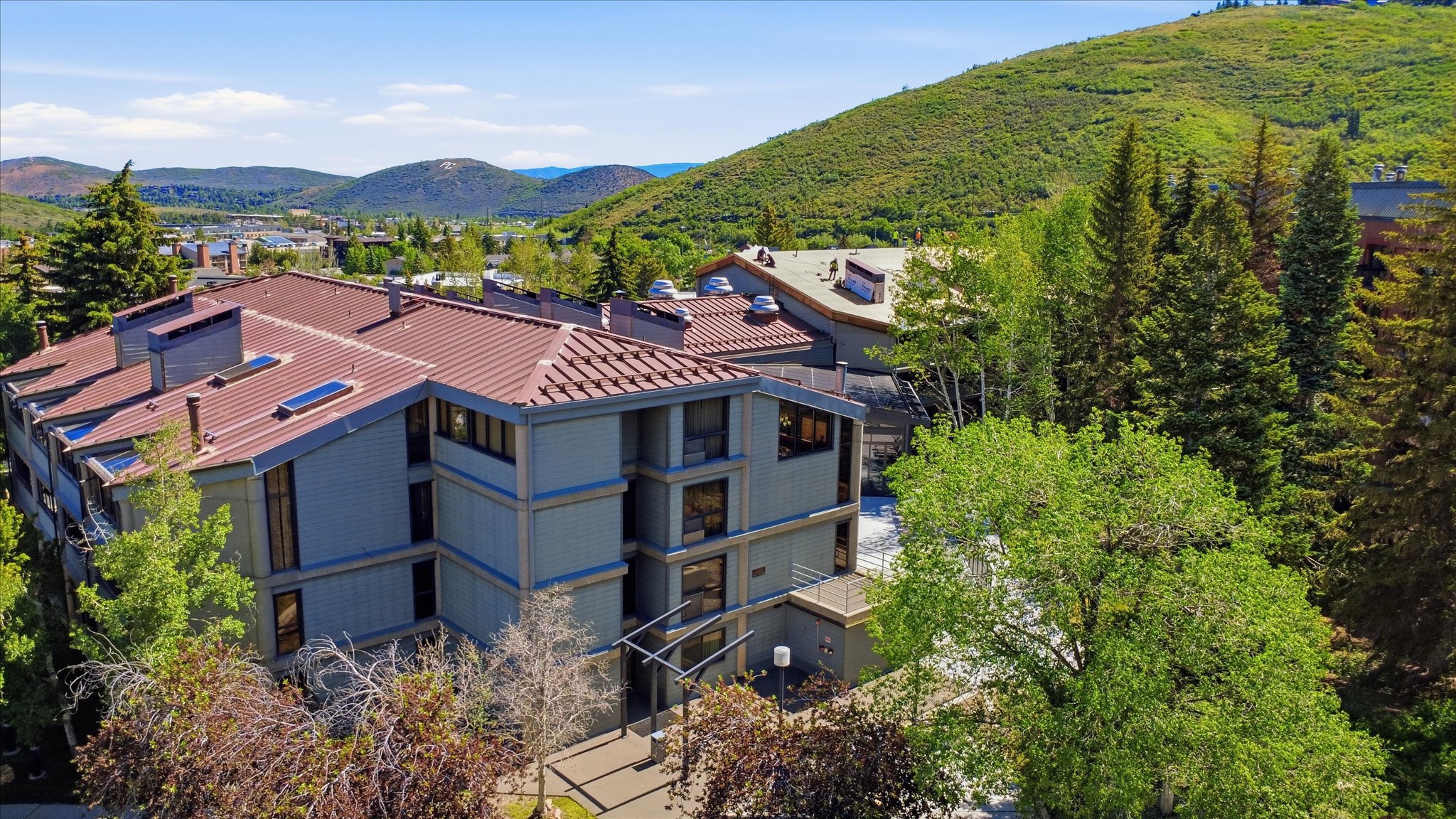 Multi-story building featuring a terracotta-hued tile roof with integrated skylights