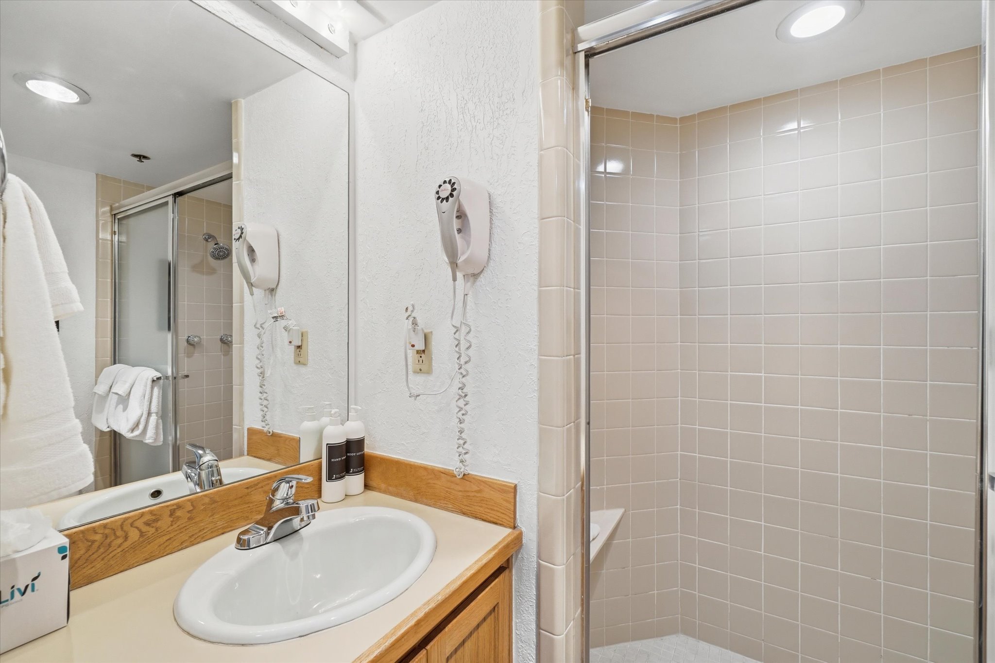 Bathroom featuring a vanity with a laminate countertop, wood-finish cabinetry, and a chrome faucet
