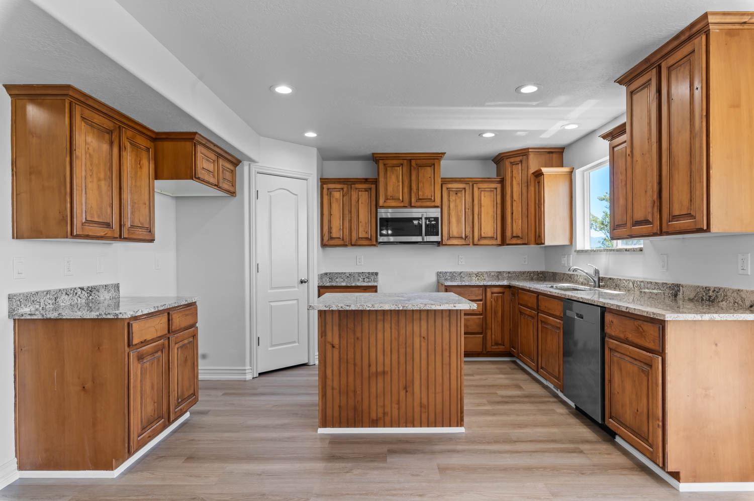 Kitchen featuring light wood-finish flooring, recessed lighting, and a white interior door