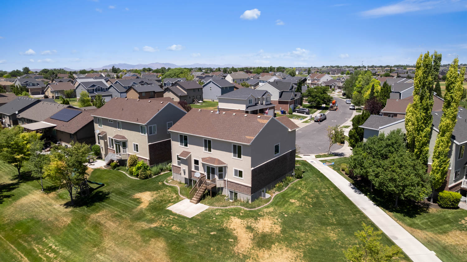 Two-story residence featuring a neutral-toned exterior and a brown shingled roof