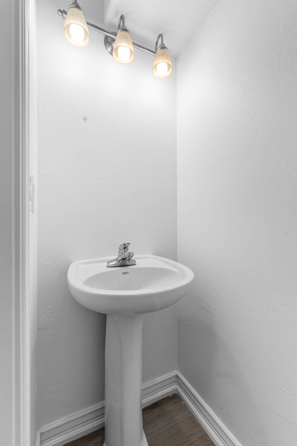 White pedestal sink with a chrome two-handle faucet