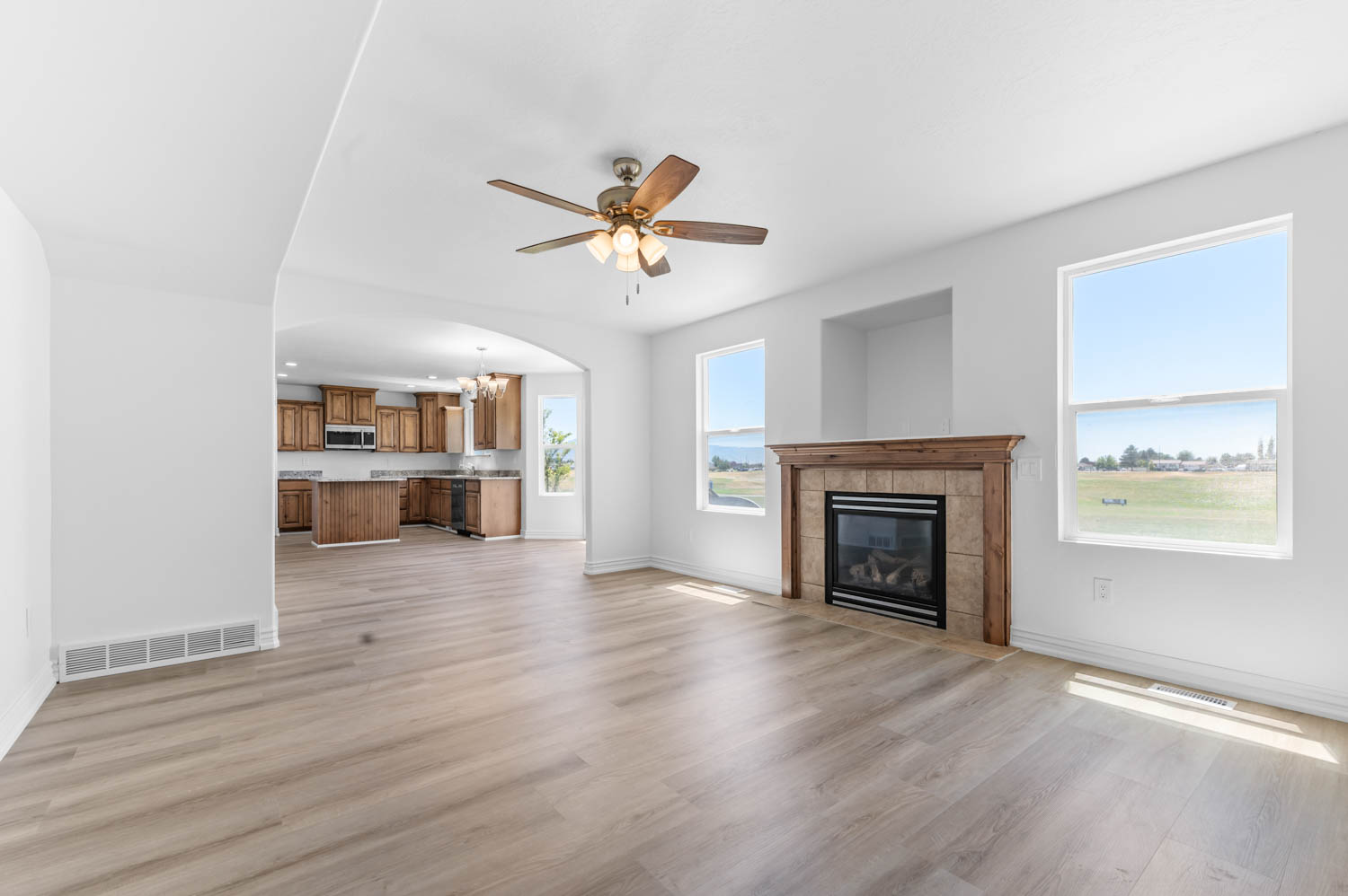 Spacious interior featuring light wood-finish flooring and a ceiling fan