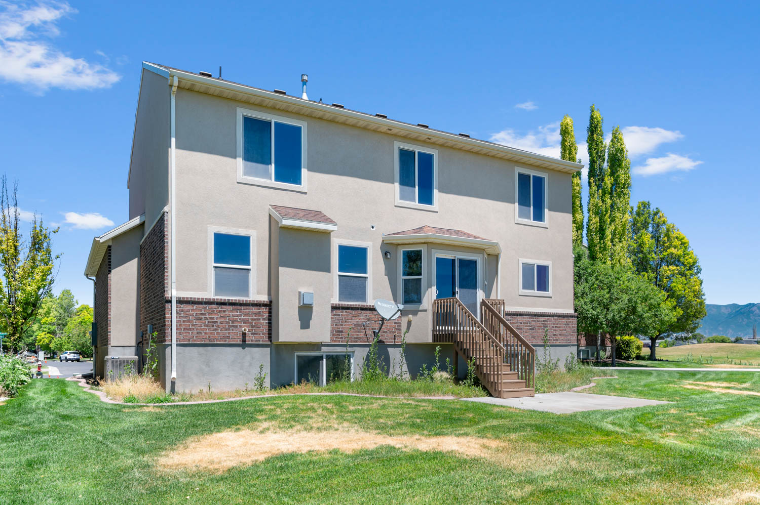 Two-story stucco and brick exterior featuring multiple windows
