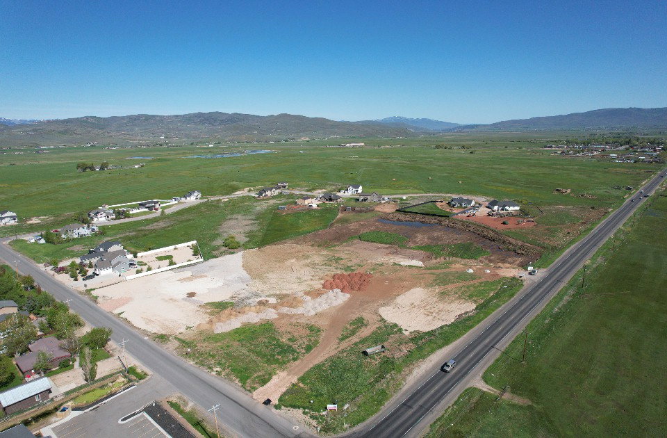 Expansive land parcel with surrounding green fields and distant mountains