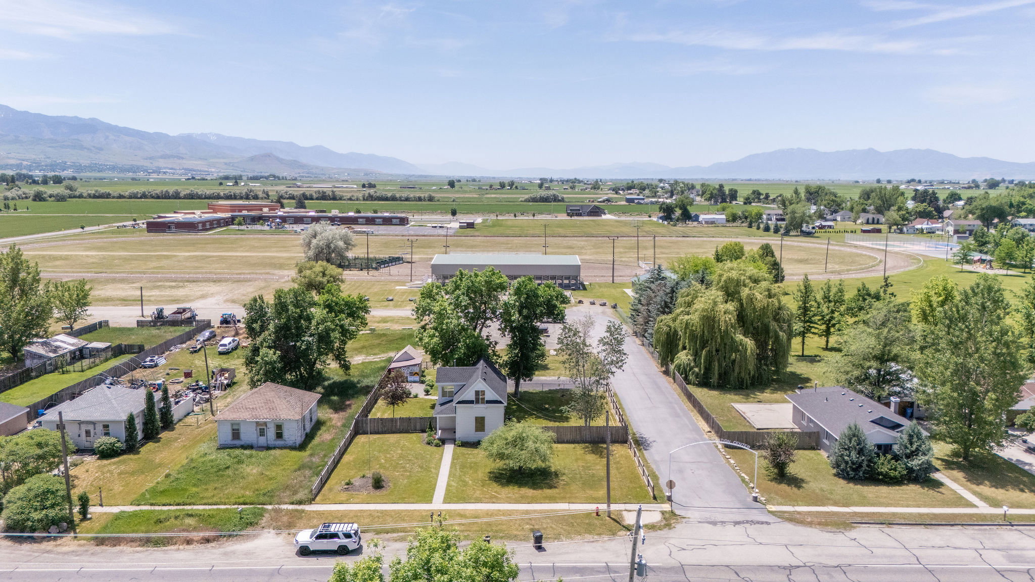 Aerial perspective showcasing the property with surrounding residential structures and agricultural fields