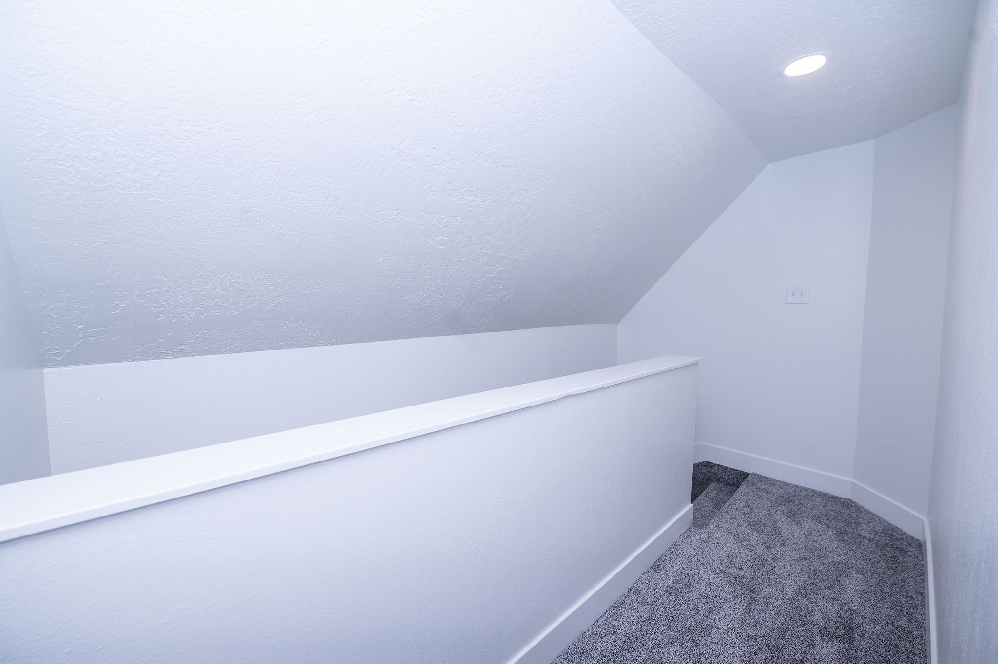 Upper level landing featuring light gray carpeting, recessed lighting, and white baseboards