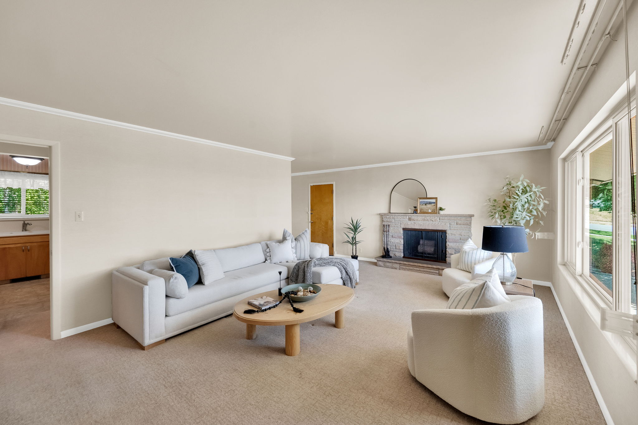 Spacious living area featuring neutral carpeting and fireplace