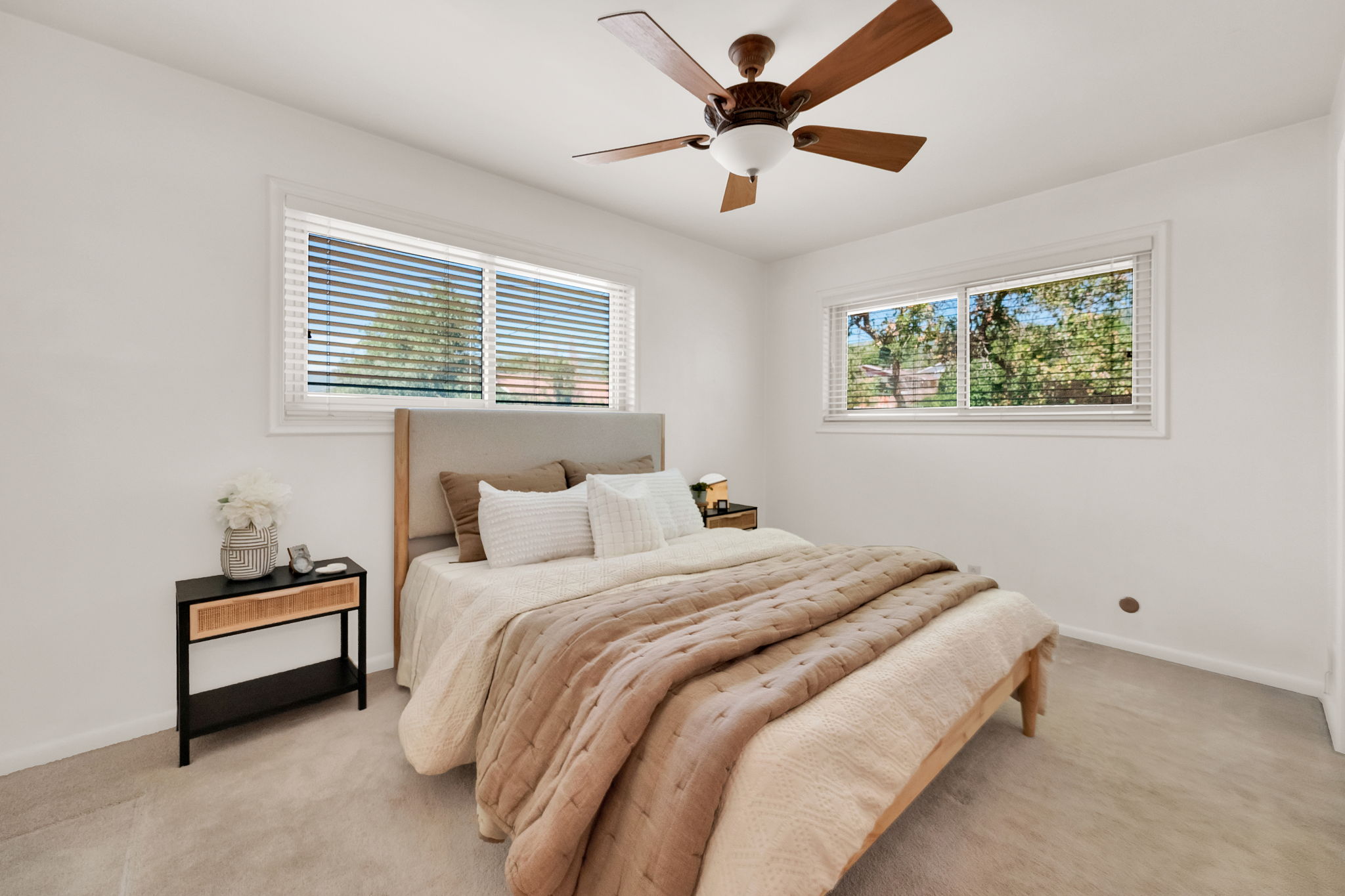 Bright room featuring two windows and ceiling fan